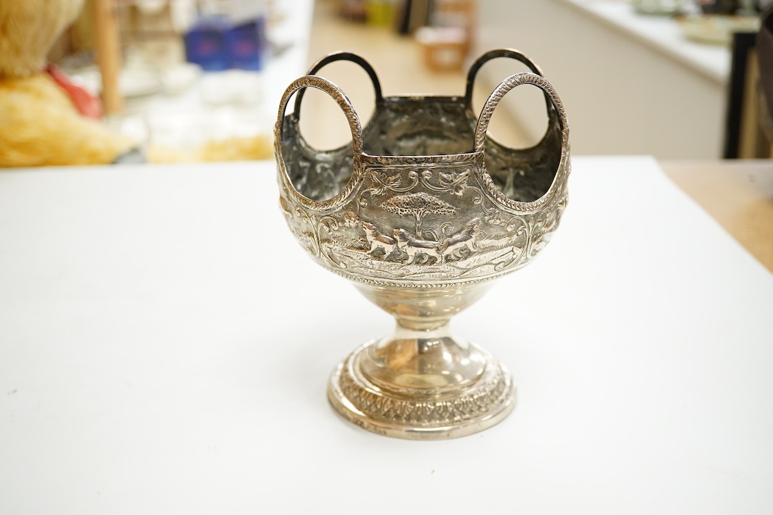 A late 19th/early 20th century Indian white metal pedestal bowl, with unusual ring handle border, embossed with continuous scene of wild animals, diameter 12.3cm, 6.3oz.